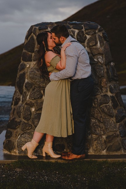 Brooke and Fabi kiss at the Hatcher Pass monument at the summit 