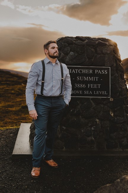 Fabi standing at the summit monument in Hatcher Pass