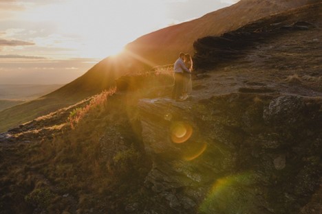 Brooke and Fabi embrace on a ledge in Hatcher Pass