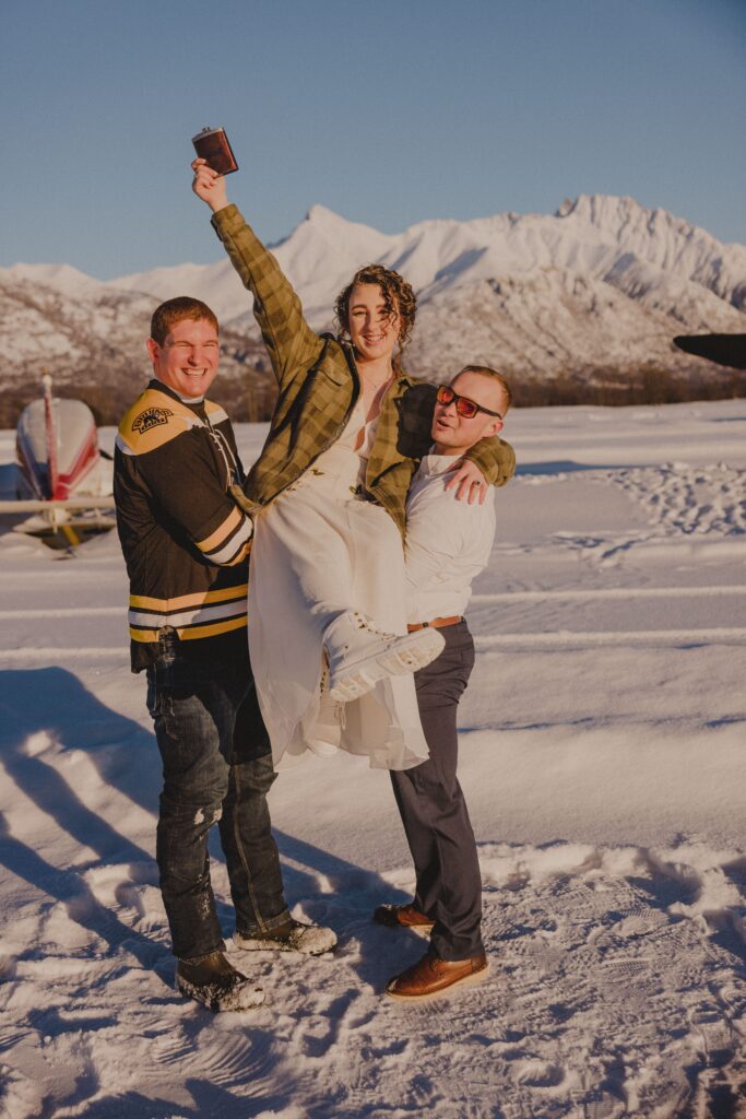 Zoe is hoisted up by her groom and the officiant.