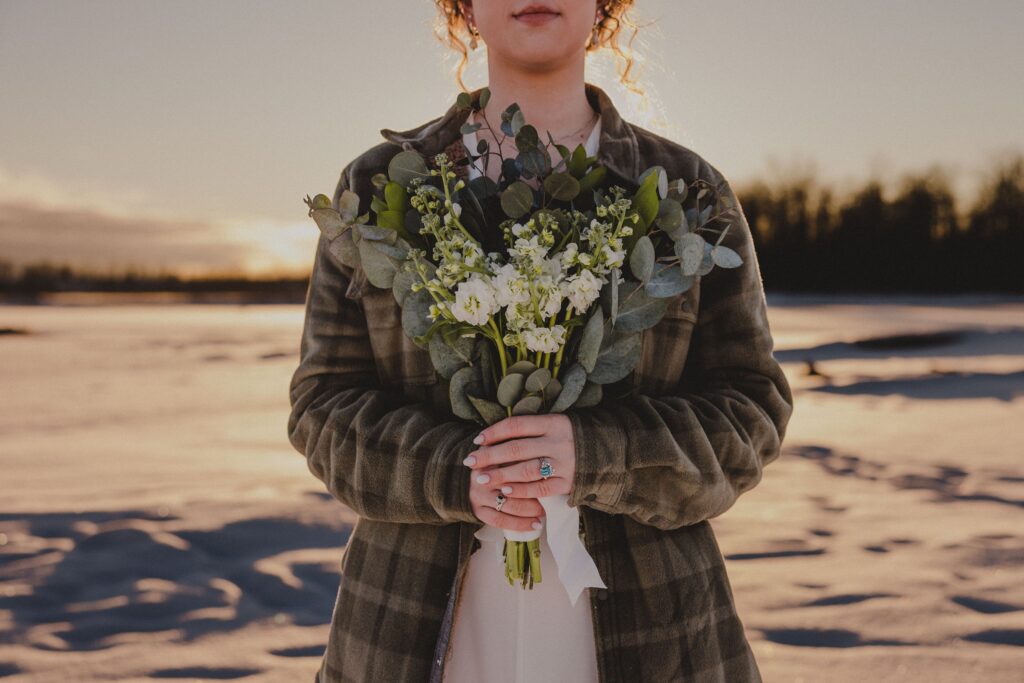 The bride shows off her eucalyptus bouquet and stunning gemstone ring.