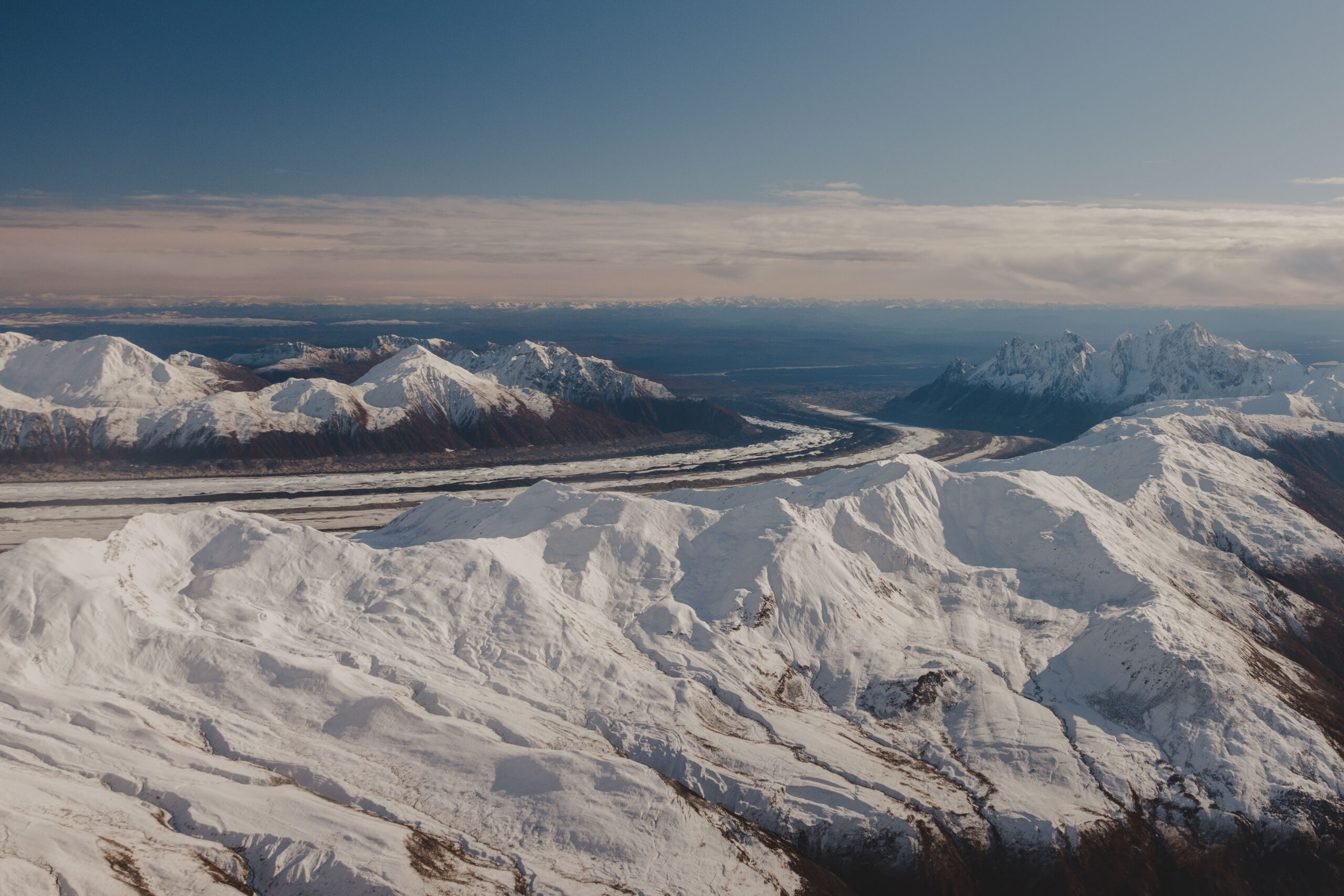 Image of a glacial valley and the evidence of receding glaciers and the impact on the surrounding mountains.