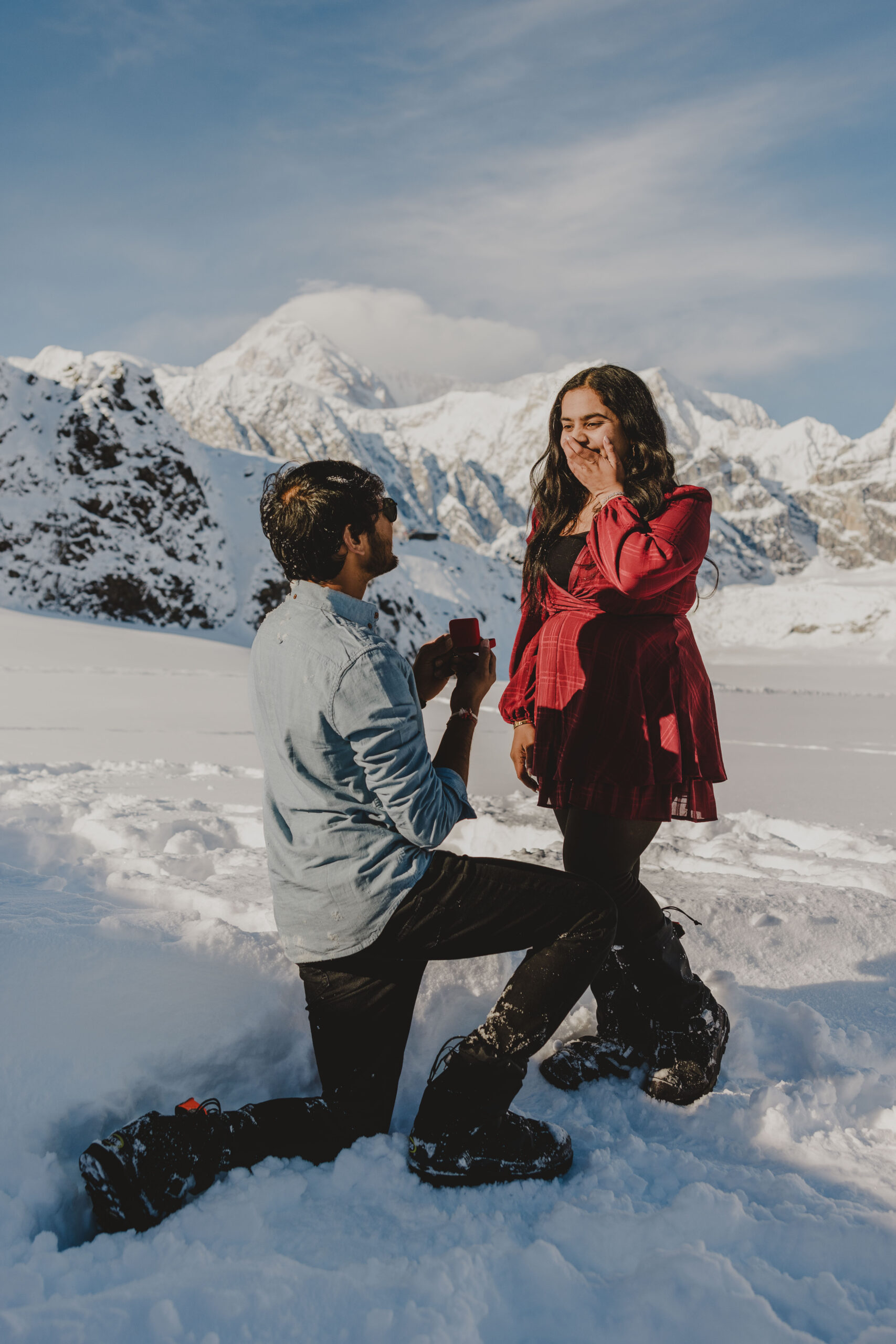 Denali peeking out behind the couple as he proposes to his future wife.